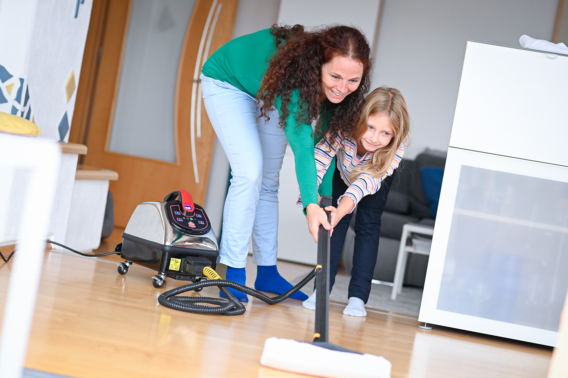 Mum and little daughter have fun mopping the floor with the Thermostar dry steam cleaner